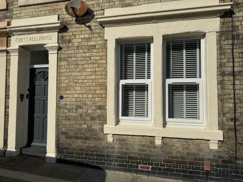a brick building with two windows and a door at Station Retreat Cullercoats Free Onsite Parking in Cullercoats