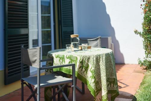a table with a green and white table cloth on it at Casa de Colares - Sintra Beach Pool Surf Getaway Work and Play in Colares