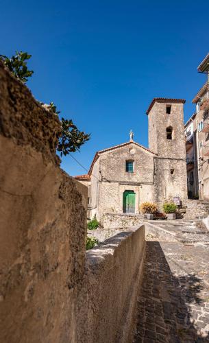 an old stone building with a church in the background at PIAZZA LAURINO Apartments in Laurino
