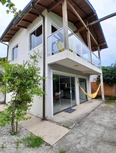 a house with a balcony with a glass door at Casa da Amandinha in Florianópolis