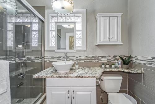 ein Badezimmer mit Waschbecken, Toilette und Dusche in der Unterkunft Tampa Ybor Bungalow in Tampa