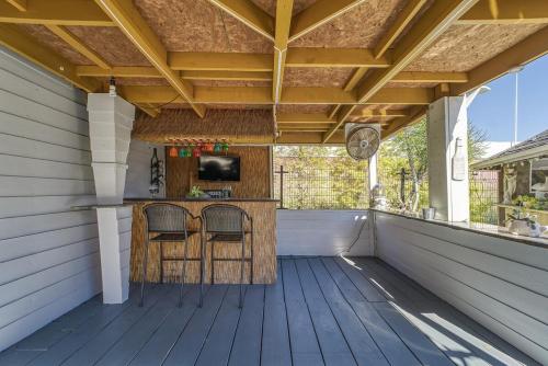 a covered porch with a bar with two chairs at Tampa Ybor Bungalow in Tampa