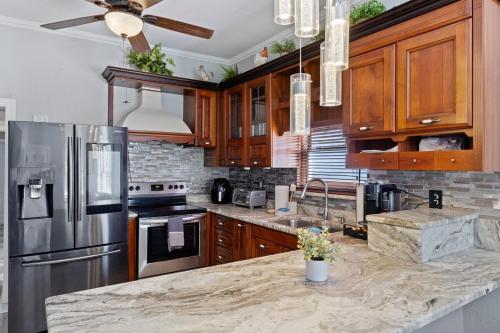 a kitchen with wooden cabinets and a stainless steel refrigerator at Tampa Ybor Bungalow in Tampa