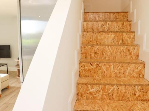a wooden staircase in a house with a white wall at Ballyconnery Bliss in Colligan Bridge