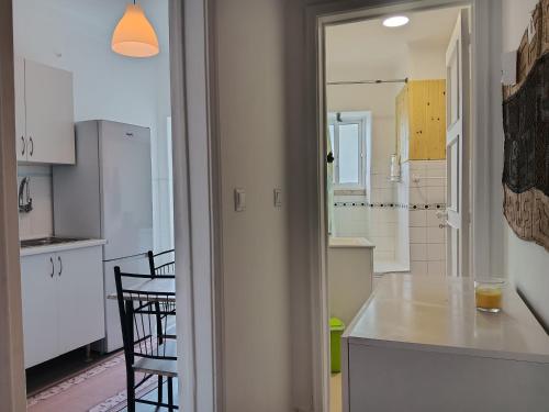 a kitchen with white cabinets and a table and chairs at Milena 2 in Lisbon