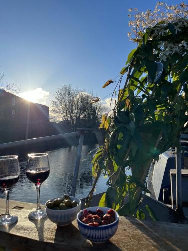 a table with two glasses of wine and a bowl of fruit at Potato in London