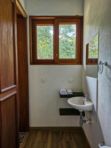 a bathroom with a sink and a window at Caminos Alojamiento in Jardin