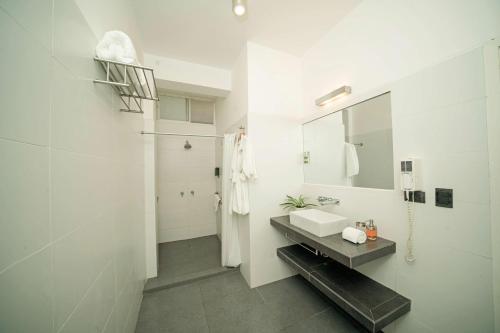 a white bathroom with a sink and a mirror at Tucan Suites Tarapoto - Hotel Asociado Casa Andina in Tarapoto