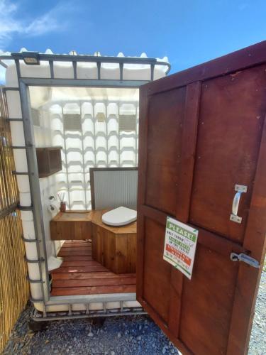 a bathroom with a toilet on a wooden deck at 2 Waipu Thunderdomes Eco Off-grid Luxury Glamping Seaview Dome in Waipu