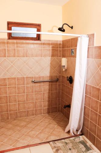 a bathroom with a shower with a shower curtain at Hotel Orocay Lodge in Cartago