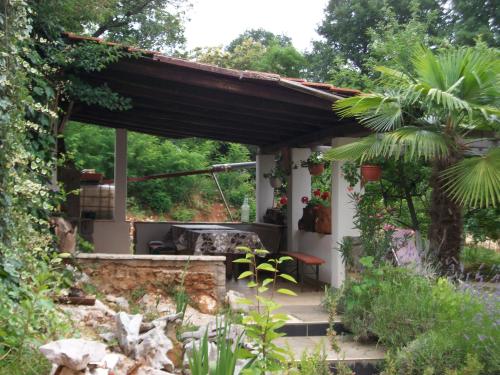 un giardino con pergolato e patio di Apartments Kristic a Lovran (Laurana)
