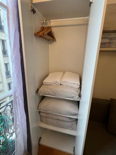 un placard avec quatre serviettes pliées dedans dans l'établissement Studio Île Saint-Louis (Cathédrale Notre Dame), à Paris