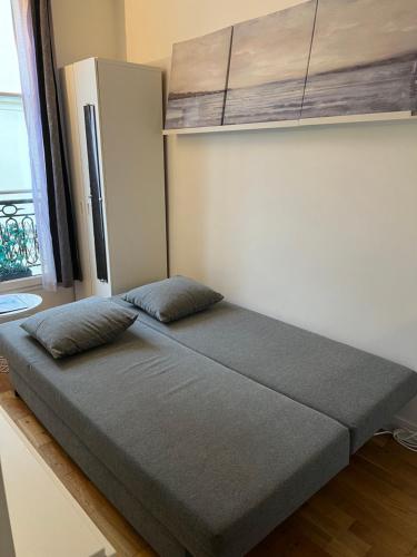 un lit avec deux oreillers dessus dans une chambre dans l'établissement Studio Île Saint-Louis (Cathédrale Notre Dame), à Paris