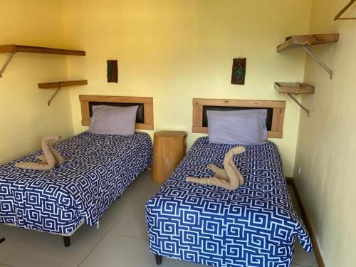 two beds sitting next to each other in a room at Hotel Orocay Lodge in Cartago