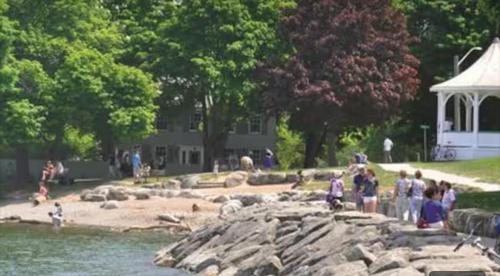 a group of people standing around a pond in a park at Hummingbird Haven Bed & Breakfast Luxury Suite With Terrace & Seasonal Lake Views Located in Historic Old Town Niagara-On-The-Lake in Niagara-on-the-Lake
