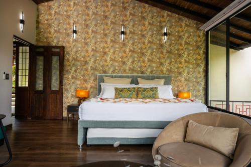 a bedroom with a large bed and a chair at GreenOriental Resort in La Vega