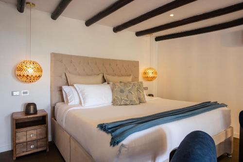 a bedroom with a large bed and two lights at GreenOriental Resort in La Vega