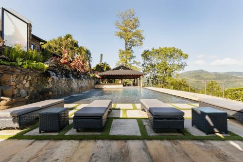a swimming pool with benches and a gazebo at GreenOriental Resort in La Vega