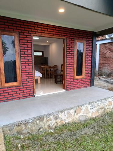 a brick house with a patio and a dining room at Villa Lumbung Salak in Bogor