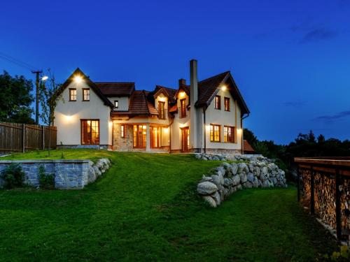 a house with lights on the front of it at night at Villa in Varva ov near Ski Slopes in Varvažov
