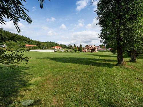 a large green field with a tree in the middle at Villa in Varva ov with Garden and Barbecue in Varvažov
