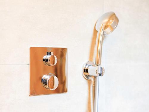 a shower with a copper shower head on a wall at Villa in Cervene Janovice near Kutna Hora Castle in Červené Janovice