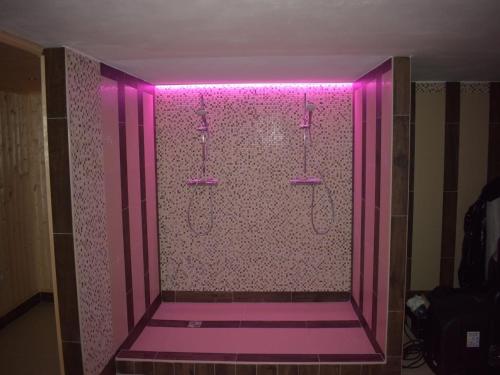 a pink bathroom with a shower with a pink lighting at Villa in Le any with Sauna and Jacuzzi in Lešany