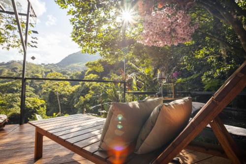a wooden bench on a deck with a view of the mountains at GreenOriental Resort in La Vega