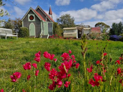 a church with a bench and flowers in a field at Romantic Retreat Pod by Historic Church on Wine Route in Bangor