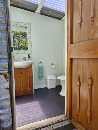 a bathroom with a sink and a toilet and a mirror at Romantic Retreat Pod by Historic Church on Wine Route in Bangor