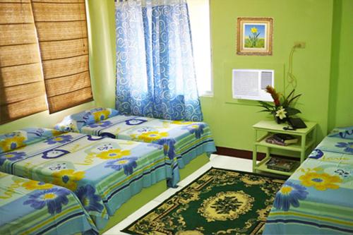 a bedroom with two twin beds and a rug at Pacific Pensionne in Cebu City