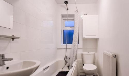 ein Badezimmer mit Toilette und Waschbecken und einem Fenster in der Unterkunft Charming 3-Bedroom Home Near NEC, Birmingham Airport & Bullring in Birmingham