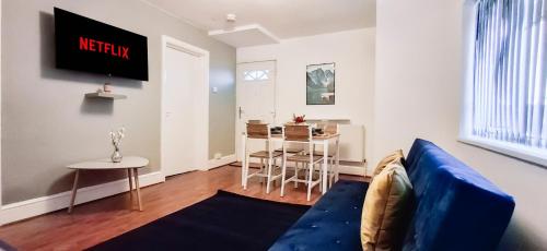 a living room with a blue couch and a table at Charming 3-Bedroom Home Near NEC, Birmingham Airport & Bullring in Birmingham