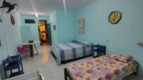 a bedroom with two beds and a table and a table at Refúgio da Mangueira in Barra dos Coqueiros