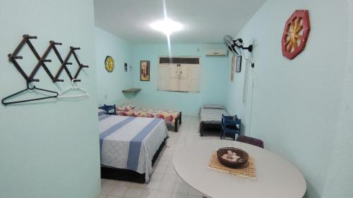 a bedroom with a bed and a table in a room at Refúgio da Mangueira in Barra dos Coqueiros
