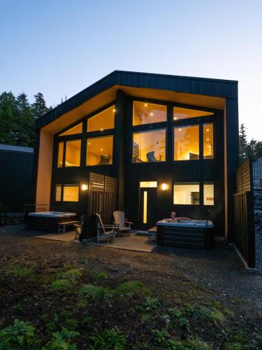 a large glass house with a bed in front of it at Calmwater Retreat New 2 br Hot Tub in Ucluelet