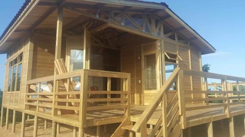 a large wooden house with a large deck at Hostal Finca San Martín De Loba in Los Naranjos