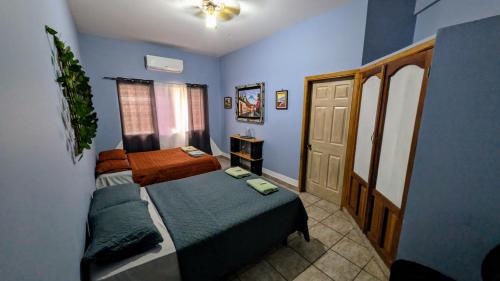 a small bedroom with a bed and a door at Guamacayan House in Copan Ruinas