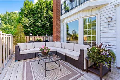 a patio with a couch and a table on a deck at Hummingbird Haven Bed & Breakfast Luxury Suite With Terrace & Seasonal Lake Views Located in Historic Old Town Niagara-On-The-Lake in Niagara-on-the-Lake