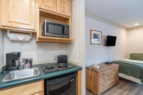 a small kitchen with a sink and a microwave at Mountainside Inn 312 by Alpine Lodging Telluride in Telluride