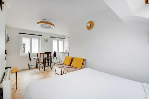 une chambre avec un lit, une table et des chaises dans l'établissement Résidence Antoine - 2P ou 4P -Bastille, à Paris
