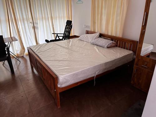 a bedroom with a bed with a wooden frame at MANAPURATH Homestay in Mamalakandam