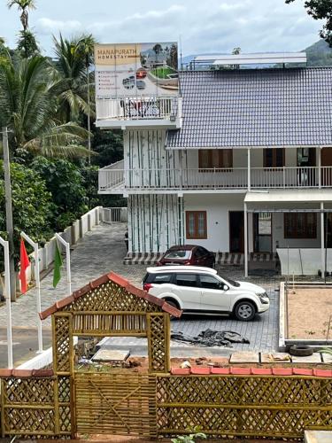 a white car parked in front of a building at MANAPURATH Homestay in Mamalakandam