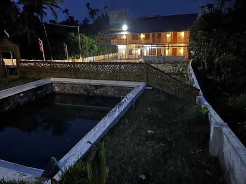 a pool of water in front of a building at night at MANAPURATH Homestay in Mamalakandam