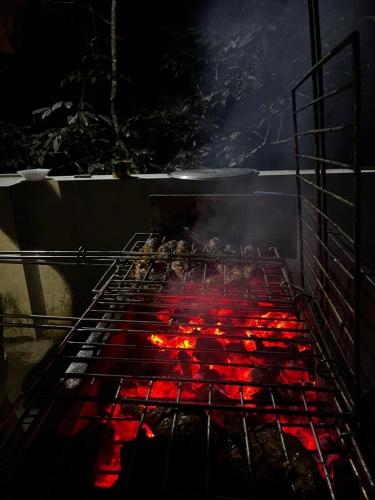 a grill with a bunch of red food on it at MANAPURATH Homestay in Mamalakandam