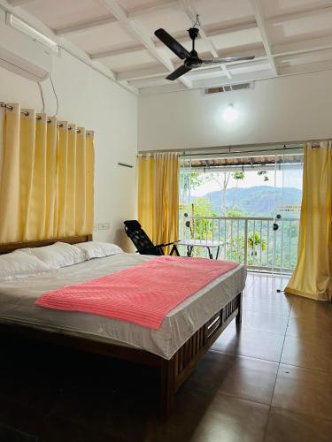 a bedroom with a large bed and a balcony at MANAPURATH Homestay in Mamalakandam