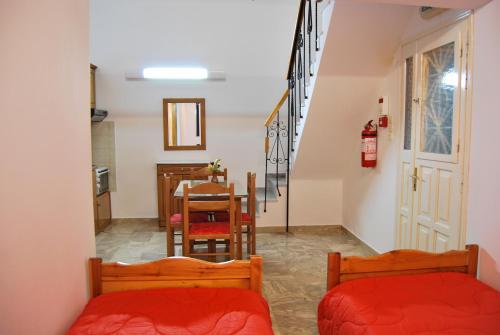 a room with two beds and a dining room with a table at Houdis Houses in Paralion astros