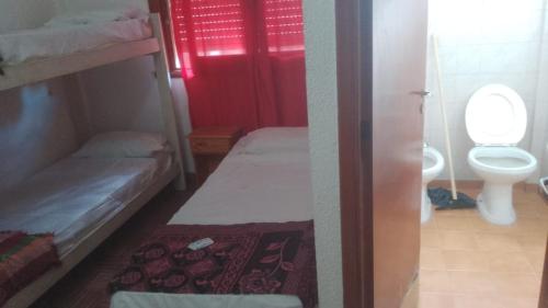 Una pequeña habitación con dos literas y un baño. en Hotel Monte Castello, en Villa Gesell