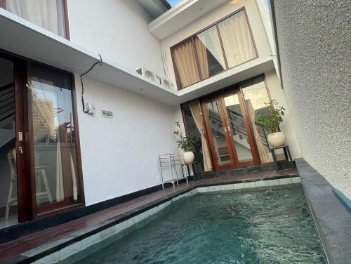 a house with a swimming pool in front of a building at LaJimbar Villa Sanur Bali in Ketewel
