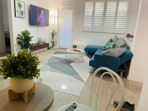 a living room with a couch and a table at 2 bedroom Beach cafes shops bus all a walk away in Deewhy
